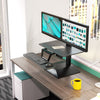 Workrite Solace Electric standing desk converter with dual monitors in an office